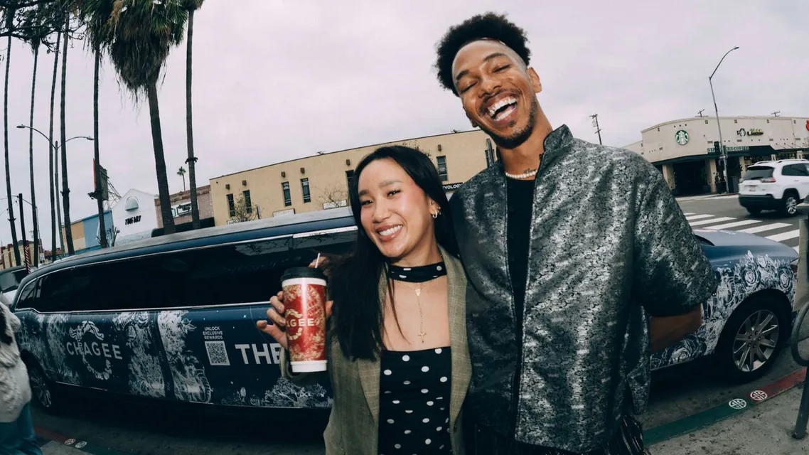 A couple on a city street beside a taxi